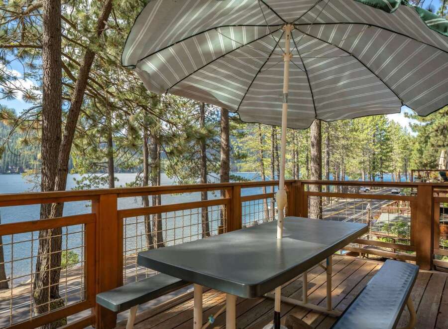 Enjoy breathtaking lake views from this charming deck, complete with a picnic table and umbrella, perfect for al fresco dining.