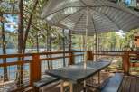 Enjoy breathtaking lake views from this charming deck, complete with a picnic table and umbrella, perfect for al fresco dining.