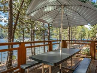 Enjoy breathtaking lake views from this charming deck, complete with a picnic table and umbrella, perfect for al fresco dining.