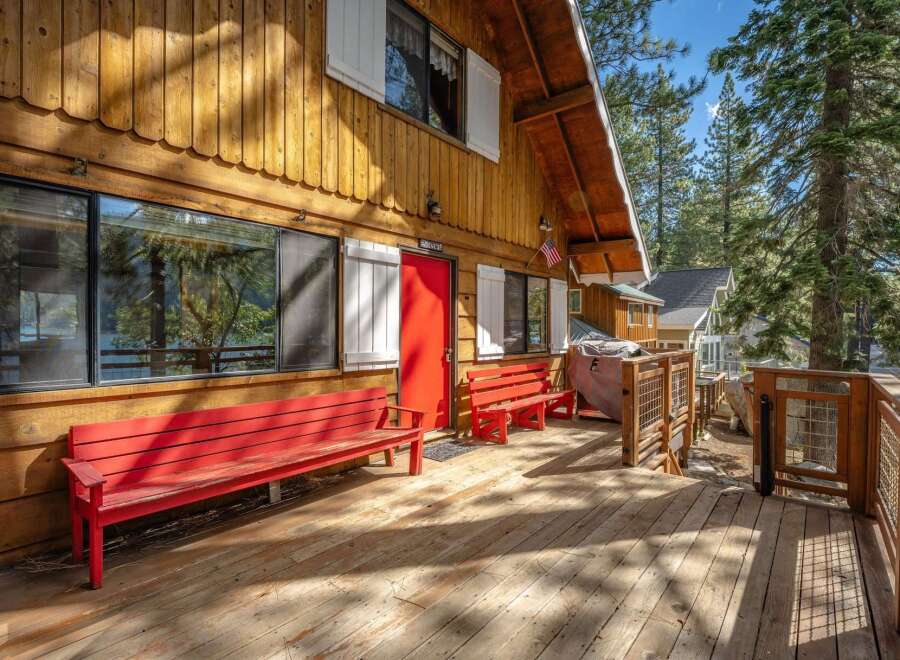 Experience lakeside living in this charming wooden cabin, featuring a spacious deck perfect for enjoying the serene water views.