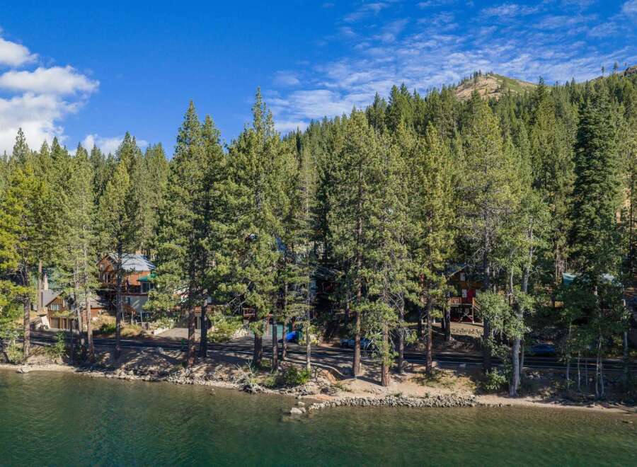 Nestled amongst towering pine trees, this property offers a serene lakeside retreat with stunning natural beauty.