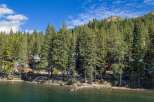 Nestled amongst towering pine trees, this property offers a serene lakeside retreat with stunning natural beauty.