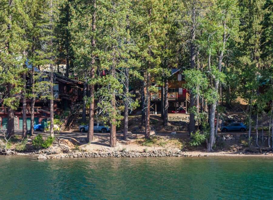 Nestled among tall pine trees on the serene lakefront, this property offers a unique blend of rustic charm and modern comfort.