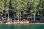 Nestled among tall pine trees on the serene lakefront, this property offers a unique blend of rustic charm and modern comfort.