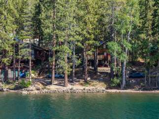 Nestled among tall pine trees on the serene lakefront, this property offers a unique blend of rustic charm and modern comfort.