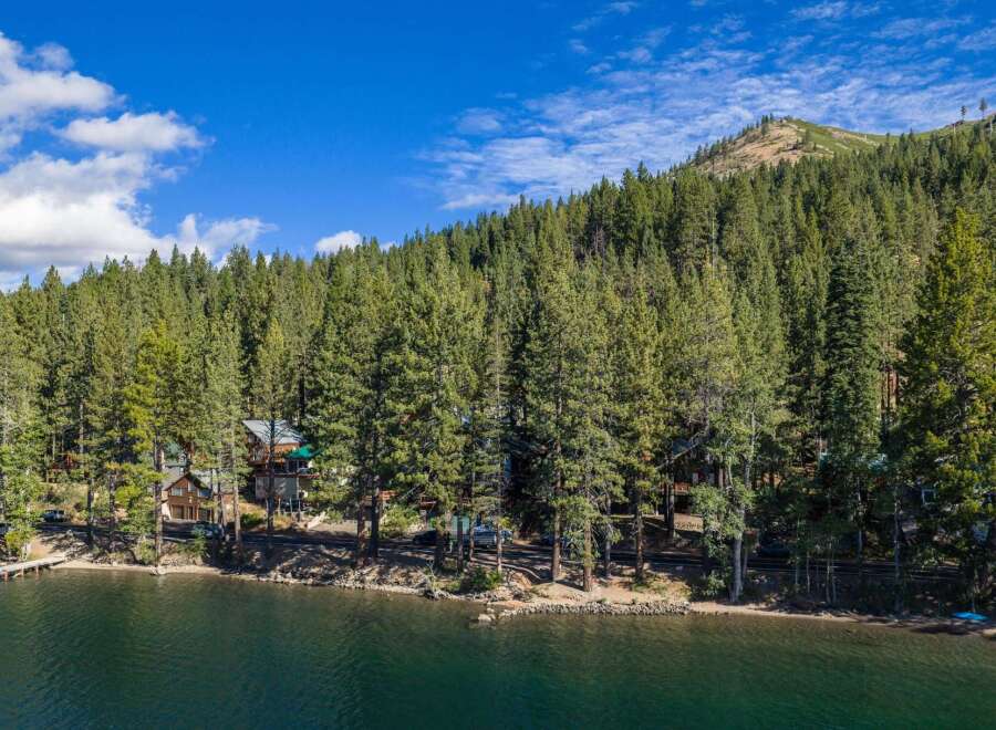 Experience lakeside living at its finest with this stunning property nestled among towering pine trees.