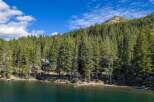 Experience lakeside living at its finest with this stunning property nestled among towering pine trees.