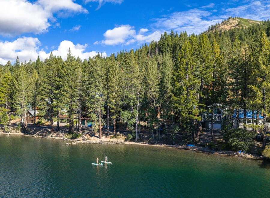 Experience lakeside living at its finest with this stunning property nestled among tall pine trees.