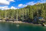 Experience lakeside living at its finest with this stunning property nestled among tall pine trees.