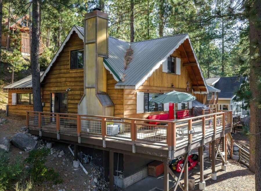 Nestled amongst tall pine trees, this charming wooden cabin offers a serene mountain retreat.
