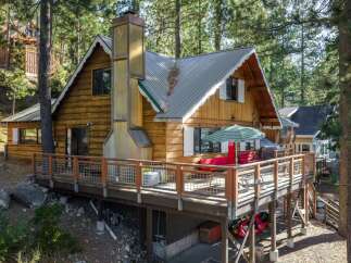 Nestled amongst tall pine trees, this charming wooden cabin offers a serene mountain retreat.