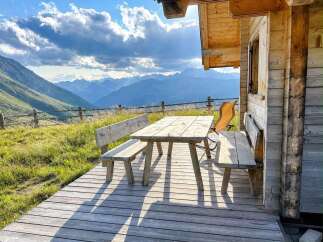 Experience breathtaking mountain views from this charming wooden cabin's expansive deck.