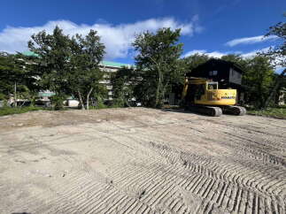 This cleared lot is ready for development, featuring a Komatsu excavator on-site, indicating active construction or preparation.