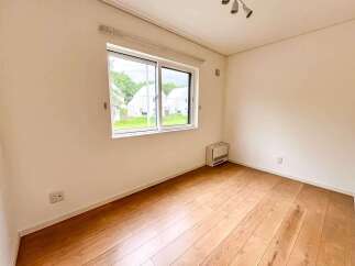 Discover this charming room featuring a large window that floods the space with natural light, offering picturesque views of the surrounding neighborhood.