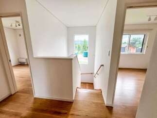 Discover modern living in this newly constructed home, featuring a bright and airy staircase with a large window offering scenic views.