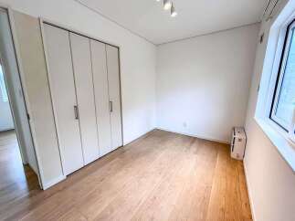 Discover this bright and airy room featuring a spacious closet with multiple doors, perfect for ample storage.