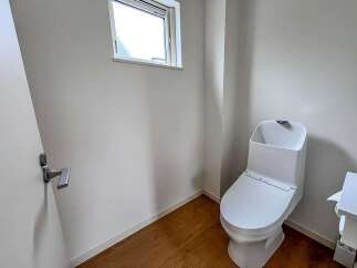 Discover modern comfort in this pristine bathroom, featuring a sleek, white toilet with integrated bidet functions.
