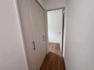 Step into a bright and airy hallway featuring a sleek, modern closet with convenient handles.