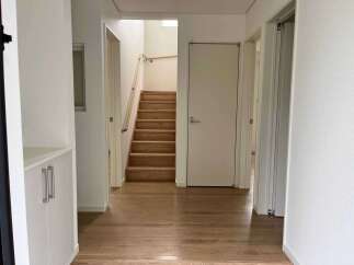 Step into this inviting hallway featuring a beautiful wooden staircase leading to the upper level.
