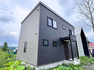 Discover modern living in this striking two-story home featuring a unique two-tone exterior of light gray and dark gray horizontal siding.