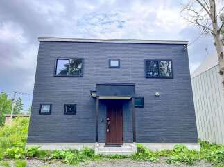 Discover modern living in this striking dark-paneled home, featuring a sleek design and ample natural light.