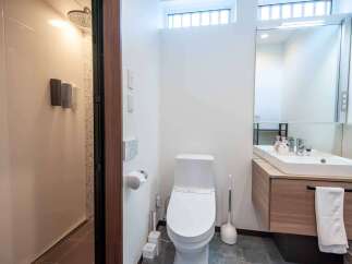 Experience modern comfort in this well-appointed bathroom, featuring a sleek toilet and a spacious vanity with a large mirror.