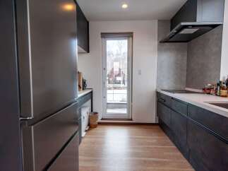 Experience modern living in this sleek kitchen featuring dark cabinetry and a clean white countertop.