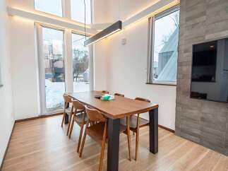 Experience modern living in this spacious dining area, featuring a large wooden table perfect for gatherings.