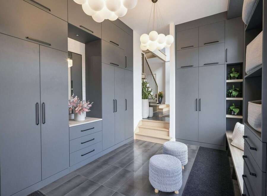 Step into a modern entryway featuring sleek, floor-to-ceiling grey cabinetry for ample storage.