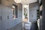Step into a modern entryway featuring sleek, floor-to-ceiling grey cabinetry for ample storage.