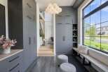 Step into a modern entryway featuring sleek grey cabinetry for ample storage and a stylish cloud-like chandelier.