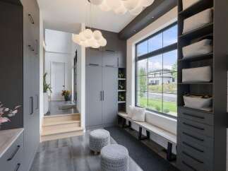 Discover modern living in this spacious entryway, featuring sleek grey cabinetry and ample storage solutions.
