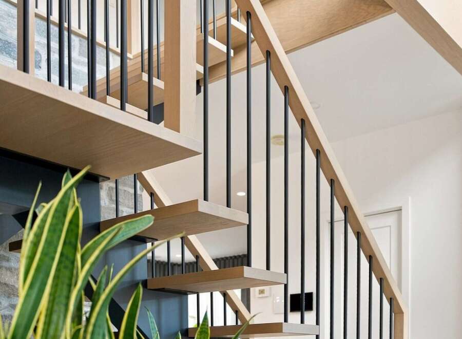 Experience modern living with this stunning staircase, featuring sleek floating wooden treads and a minimalist black metal railing.