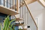 Experience modern living with this stunning staircase, featuring sleek floating wooden treads and a minimalist black metal railing.