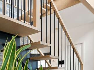 Experience modern living with this stunning staircase, featuring sleek floating wooden treads and a minimalist black metal railing.