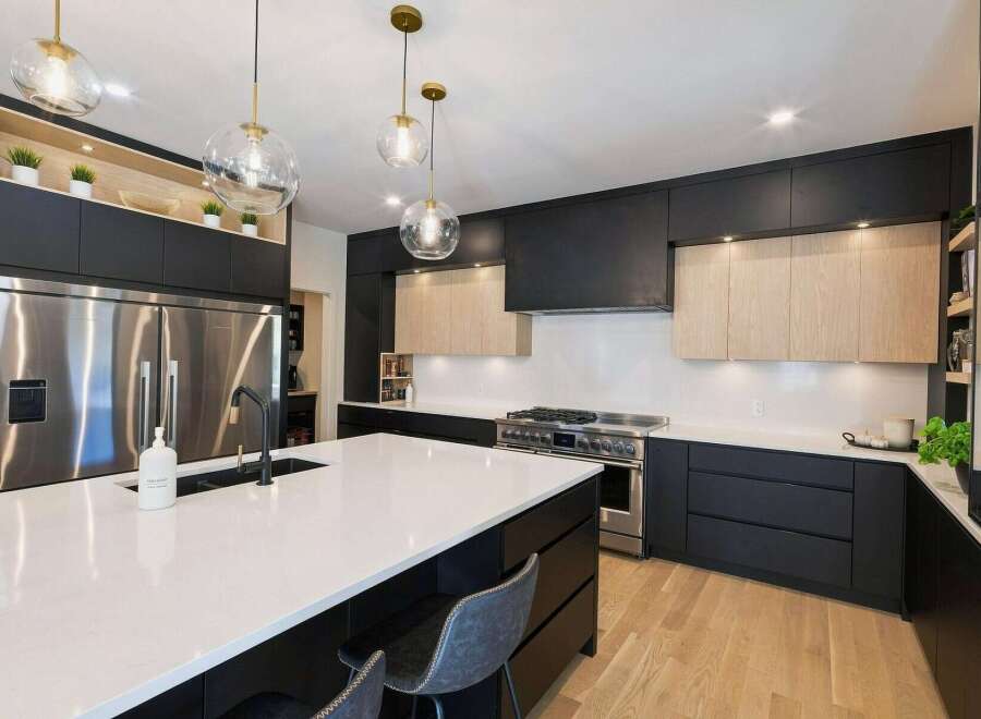 Experience modern luxury in this stunning kitchen, featuring sleek black cabinetry contrasted with warm wood accents.