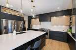 Experience modern luxury in this stunning kitchen, featuring sleek black cabinetry contrasted with warm wood accents.