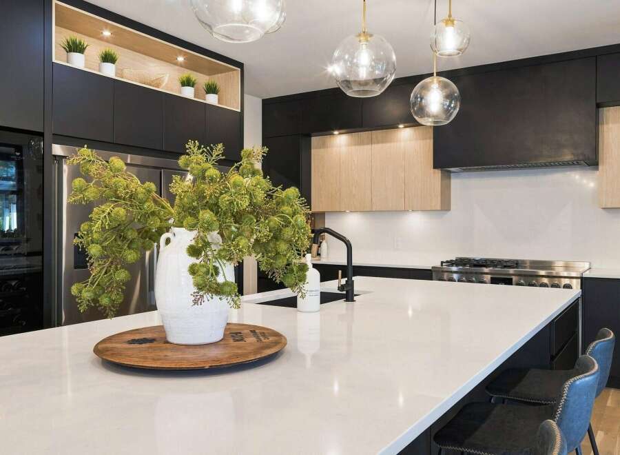 Experience luxury in this modern kitchen, featuring sleek black cabinetry and warm wood accents.