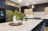 Experience luxury in this modern kitchen, featuring sleek black cabinetry and warm wood accents.