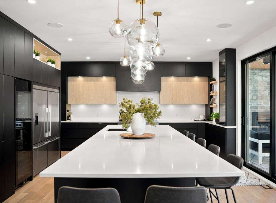 Experience modern luxury in this stunning kitchen, featuring sleek black cabinetry and warm wood accents.