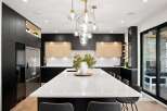 Experience modern luxury in this stunning kitchen, featuring sleek black cabinetry and warm wood accents.