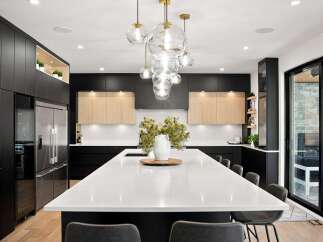 Experience modern luxury in this stunning kitchen, featuring sleek black cabinetry and warm wood accents.