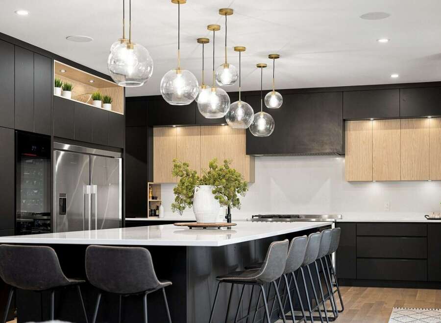 Experience modern luxury in this stunning kitchen, featuring sleek black cabinetry and warm wood accents.