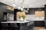 Experience modern luxury in this stunning kitchen, featuring sleek black cabinetry and warm wood accents.