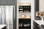 This modern kitchen boasts a sleek stainless steel refrigerator and a well-organized pantry with ample shelving for all your culinary needs.