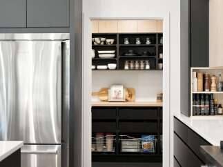 This modern kitchen boasts a sleek stainless steel refrigerator and a well-organized pantry with ample shelving for all your culinary needs.