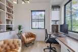 This modern home office features a spacious built-in desk with a wooden countertop, perfect for productivity.