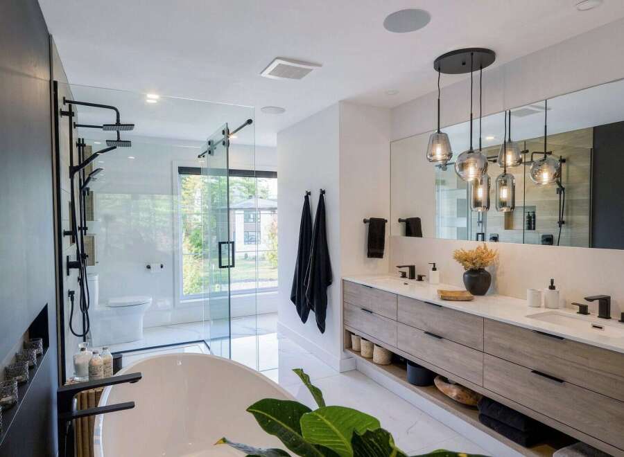 Experience modern luxury in this stunning bathroom, featuring a spacious walk-in shower with multiple showerheads and a freestanding soaking tub.