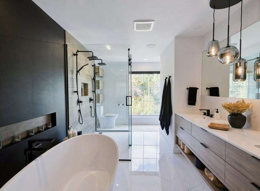 Experience modern luxury in this stunning bathroom, featuring a freestanding soaking tub and a spacious glass-enclosed shower with multiple showerheads.