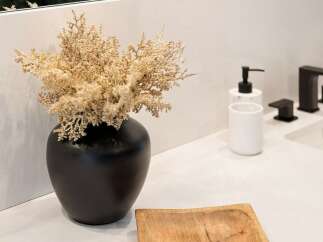 Elevate your bathroom's aesthetic with this modern vanity featuring a sleek black vase filled with dried floral accents.
